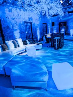 a living room filled with furniture and blue lighting