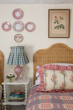 a bed room with a neatly made bed and some plates on the wall above it