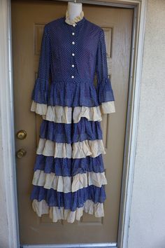 "Vintage dress by Miss Melinda. Labeled size 12. Has unique split front and ruffled skirt. Great vintage condition! Measurements taken across front lying flat 18\" armpit to armpit 14\" across empire waist 58\" length shoulder to bottom" Vintage Maxi Dress With Ruffles, Fitted Vintage Maxi Dress With Ruffles, Vintage Tiered Ruffled Dresses, Fitted Prairie Dress With Ruffles In Maxi Length, Vintage Ruffled Maxi Dress, Fitted Polka Dot Maxi Dress With Ruffles, Fitted Maxi Prairie Dress With Ruffles, Fitted Polka Dot Ruffled Maxi Dress, 1970s Style Lined Maxi Dress