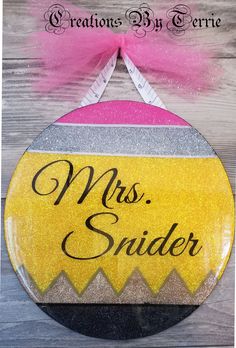 a sign that says miss snider on it with a pink bow hanging from the side