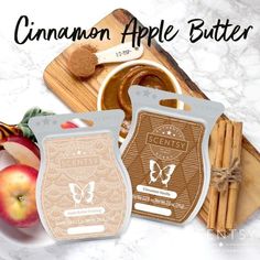 two bags of cinnamon apple butter next to apples and cinnamon sticks