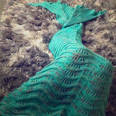 a knitted mermaid tail laying on top of a rug