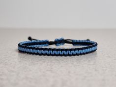 a close up of a blue string bracelet on a table