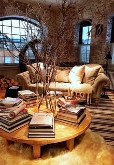 a living room filled with furniture and lots of books on top of a coffee table