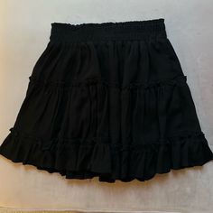 Black Skirt Never Worn. Mini. Ruffles. Super Cute. Size Small Spring Black Skirt With Elastic Waistband, Black Skirt With Elastic Waistband For Summer, Black Mini Skort With Elastic Waistband, High Waist Black Skirt With Elastic Waistband, Black Flowy Mini Skort, Flowy Black Skirt With Ruffles, Black Pleated Tiered Skort, Black Tiered Skirt With Elastic Waistband, Chic Black Tiered Skirt