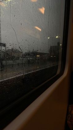 rain is falling on the window of a train