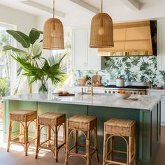 an island with stools in the middle of it next to a potted plant