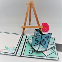 an origami birthday card with a pink flower and easel