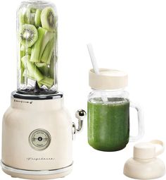 a blender filled with green smoothies next to a jar full of kiwis