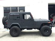 a black jeep parked in front of a white building