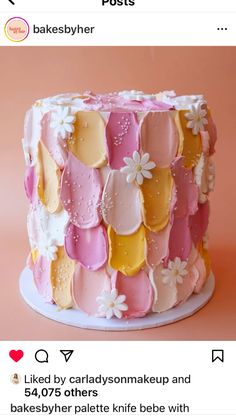 a pink and yellow cake with white flowers on it's icing is featured in the instagram post