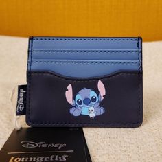 a card case with stitching on it and a disney mouse sticker next to it