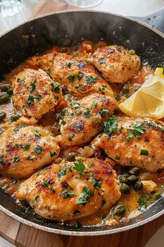 a pan filled with chicken and vegetables on top of a table