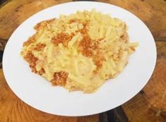 a white plate topped with macaroni and cheese on top of a wooden table