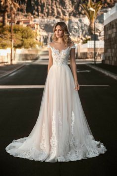 a woman in a wedding dress standing on the street