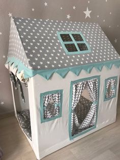 a white and blue doll house with stars on the wall