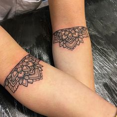 two women with matching tattoos on their arms and legs, both showing the same tattoo design