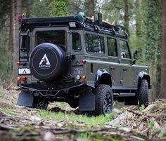 an army vehicle is parked in the woods