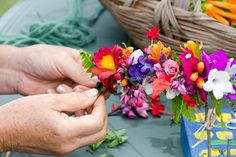 a person is arranging flowers on a table