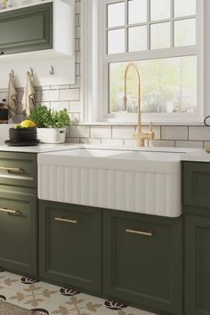 a kitchen with green cabinets and white counter tops is pictured in this image, there are plants on the window sill