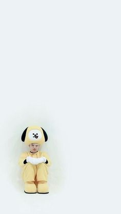 a stuffed dog sitting on top of a white wall