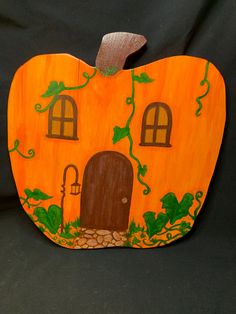 an orange painted pumpkin shaped like a house