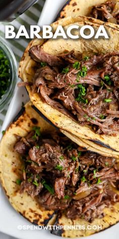 three tacos filled with shredded meat and garnished with parsley on top