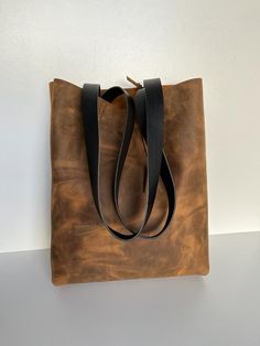 Beautiful new  raw  brown leather tote ! strong everything and then some. Brown leather bag, in a beautiful  color leather. Simple and stylish. Cowhide, in  brown color, full grain leather, thick and sturdy, and strong leather straps in the brown leather. Raw finish to appreciate this beautiful leather. This bag is made with one single piece of leather, which makes a more solid and strong bag that another one made of some sewn pieces of leather. Aprox Measures: Width -13,5 inches wide ( 35 cm ) Rustic Bags With Leather Lining For Everyday Use, Rustic Brown Bag For Everyday Use, Rugged Soft Leather Bag For Everyday, Everyday Rugged Soft Leather Bag, Rustic Bags With Leather Handles For Daily Use, Rustic Bags With Leather Handles For Everyday, Rustic Leather Shoulder Bag For Everyday Use, Rustic Everyday Bags With Leather Lining, Rugged Soft Leather Bag For Daily Use