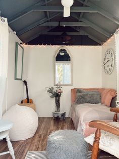 a bedroom with white walls and wooden floors