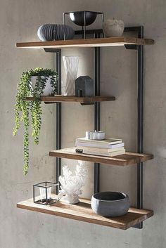 two shelves with books, vases and other items on them in a room that has concrete walls