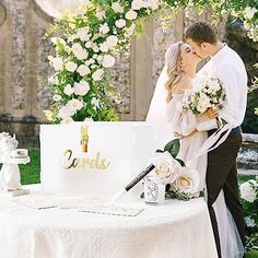 a bride and groom kissing in front of a cake with the word love written on it