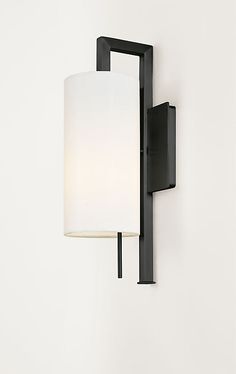 a wall light with a white shade on it's side and a black frame