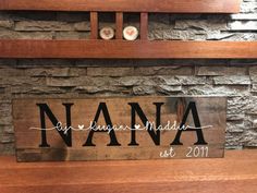 a wooden sign that says nanna on it in front of a stone fireplace mantel