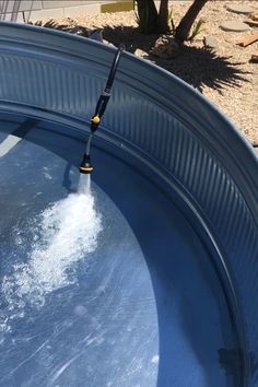 a person is using a water hose to clean the pool