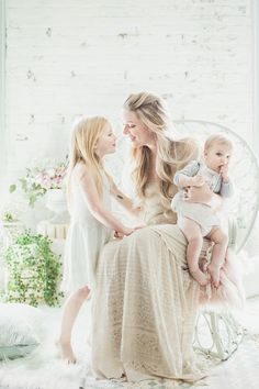 two women and a baby are sitting on a chair