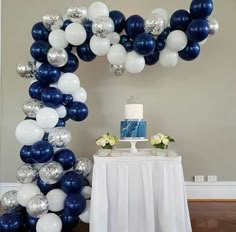 a table with a cake and balloons in the shape of an o on top of it