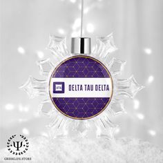 a snowflake ornament with the word delta in purple and white on it