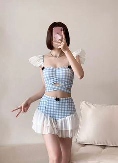 Cute Blue Gingham Ruffle Two Piece Kawaii Swimsuit with Skirt Whether you're in for tankini summer or just looking for a bit more coverage at the beach, we got you covered!(pun uninteded) Introducing our new obsession - this Japanese style two piece kawaii bathing suit. Looking for a cute swimsuit with skirt? We've got just that for you. Made with an adorable blue gingham fabric, this kawaii swimsuit features white ruffles that transform the high waisted bottoms into a skirt. Little black bows tie in the coquette influences. SIZE INFO Please choose according to your bra cup size. S - 70ABC/32ABC - 75AB/34AB M - 75BC/34BC - 80AB/36AB L - 80BC/36BC - 85AB/38AB *Standard shipping time to the US is 9-19 business days. Please consult our shipping page for shipping time estimates for other count Cute Ruffled Swimwear For Vacation, Cute Summer Tankini For Vacation, Cute Summer Tankini For Poolside, Cute Summer Vacation Tankini, Cute Sleeveless Spring Tankini, Gingham Swimwear For Summer Beach Party, Fitted Gingham Playful Swimwear, Summer Ruffled Swim Skirt, Summer Swim Skirt With Ruffles