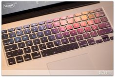 an open laptop computer sitting on top of a white table next to a black keyboard