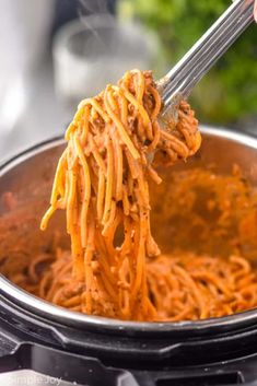 someone is stirring spaghetti into an instant pot