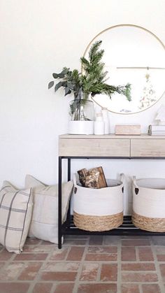 a console table with two baskets and a round mirror