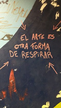 graffiti written on the side of a wall with writing in spanish and english, next to an orange fire hydrant