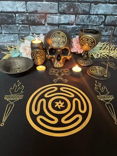 a table topped with skulls and candles next to other items on top of a brick wall