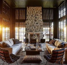 a living room filled with furniture and a stone fireplace