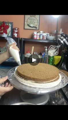 a woman is making a cake with frosting on the top and icing on the bottom