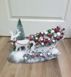 a christmas scene with a sleigh and reindeer on the ground next to a door