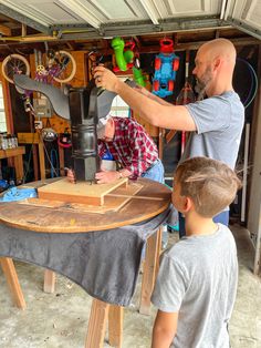 a man and two boys are working on a project