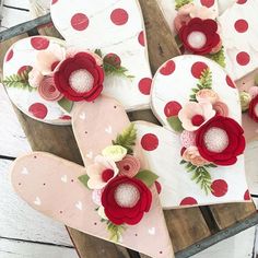 heart shaped paper flowers are arranged on top of wooden boards in the shape of hearts