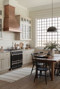 a kitchen with an oven, stove and dining table in front of the window that overlooks the ocean