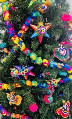 a brightly colored christmas tree with ornaments on it